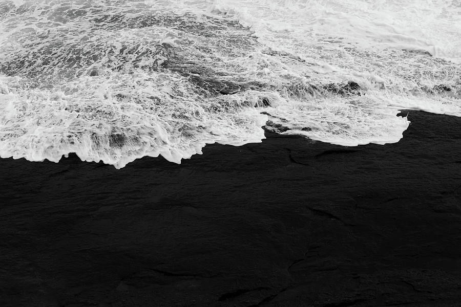 A Wave Hitting the Shore of a Beach in Black and White