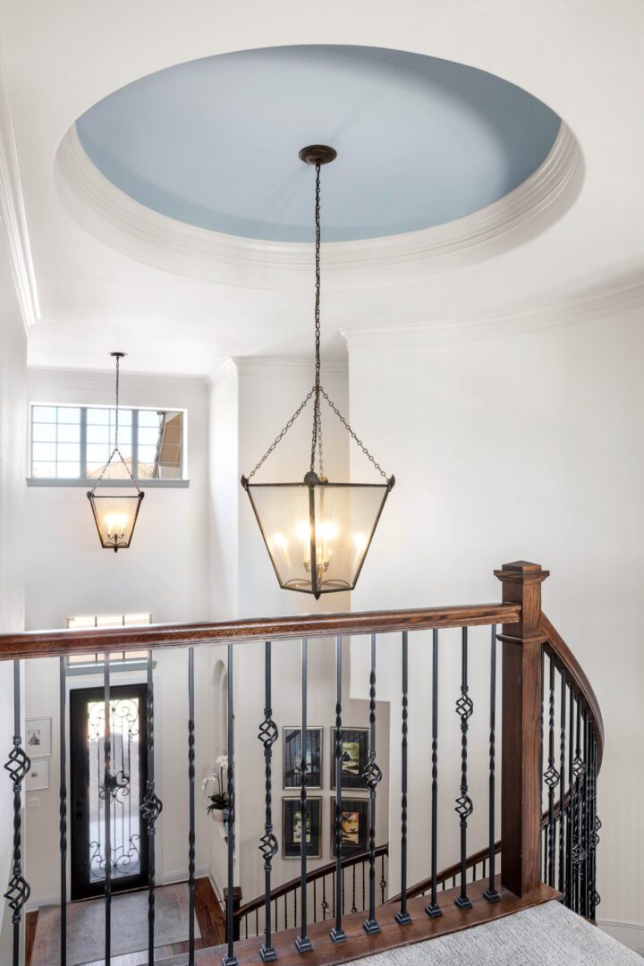two chandeliers and stair case in a house